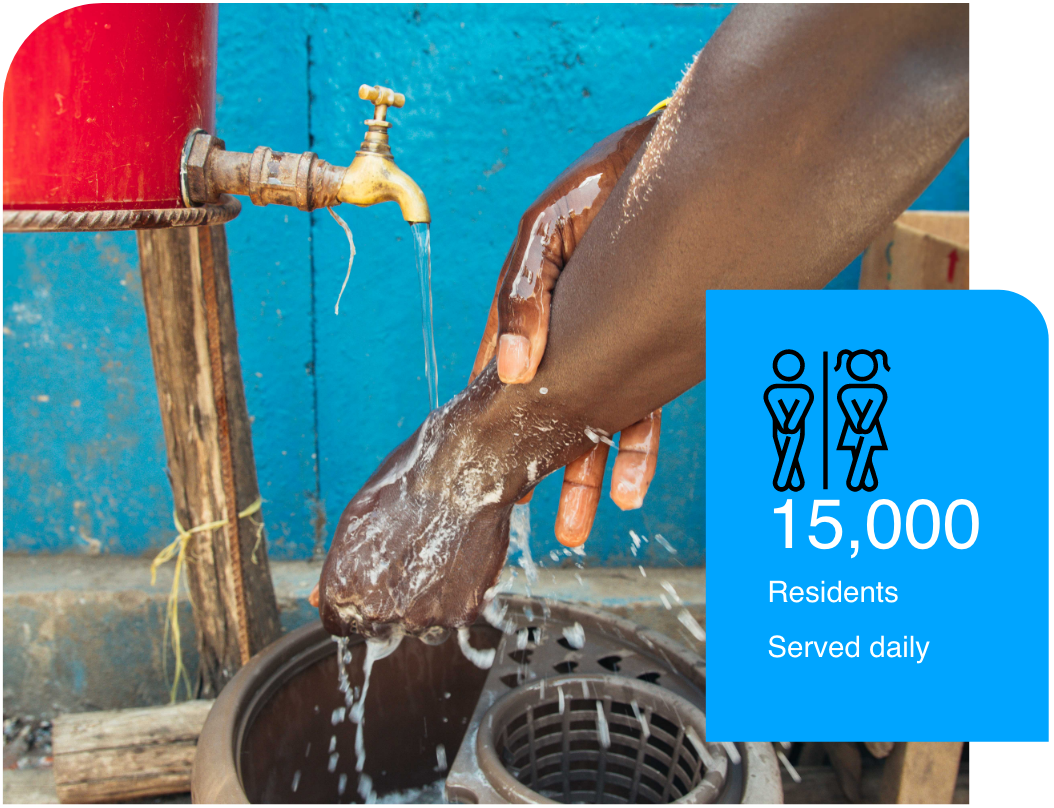 Resident washing hands on a tap provided by the Fresh Life choo system